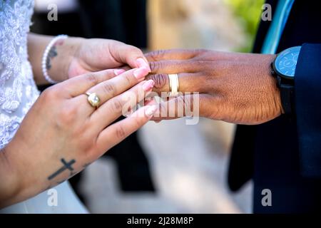Bride putting ring on groom`s finger Stock Photo